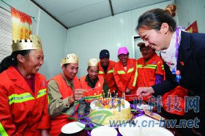 社區(qū)工作人員為集體過生日的三名環(huán)衛(wèi)工人點上生日蠟燭。 本報通訊員 趙松 攝
